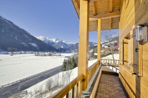 A wooden balcony with a view of a snow-covered landscape and mountains. - Scenic Valley Chalet in Austria (Wald im Pinzgau)