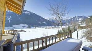 A wooden balcony with a snow-covered ground, overlooking a mountainous landscape with a clear sky. - Scenic Valley Chalet in Austria (Wald im Pinzgau)