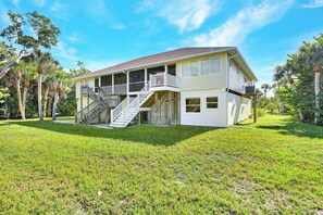 A two-story house with a porch, a staircase, and a fenced yard.
