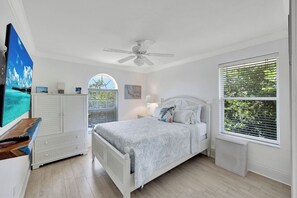 A bedroom with a bed, a ceiling fan, a TV, a dresser, and a window with blinds. - Rabbit road oasis just a short stroll to The Gulf! (Sanibel)