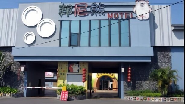Ein Gebäude mit einem Schild, das „Motel“ steht, und einem Schweine-Logo.
