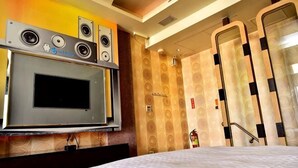 Ein Hotelzimmer mit eingebauter Mikrowelle, einem Bett und einer Duschkabine.