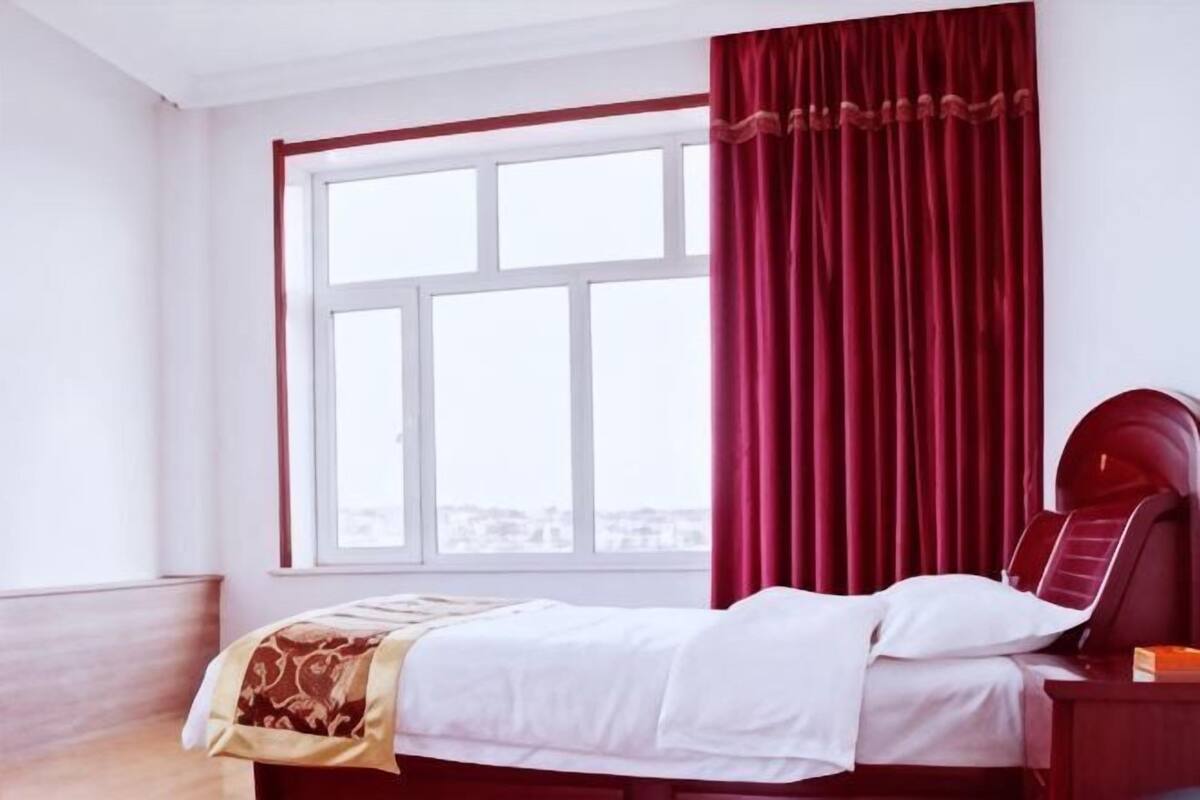 Une chambre d’hôtel avec un lit, une fenêtre et une vue sur la ville.