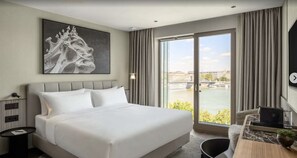 A hotel room with a large bed, a view of a river, and a cityscape. - Leon Hotel & Lounge (Budapest)