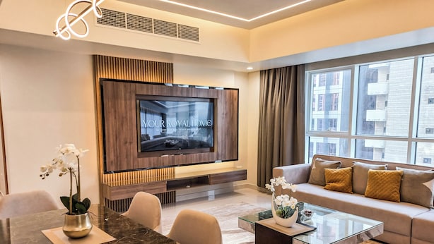Una sala de estar moderna con un televisor de pantalla plana, una mesa de comedor y un sofá.