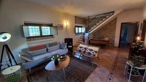 A living room with a sofa, coffee table, and a staircase leading to another level.