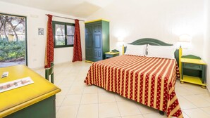 Ein Schlafzimmer mit Bett, Nachttischen, einem Schreibtisch und einem Fenster mit Vorhängen.