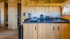 Una cocina rústica de madera con encimera negra, armarios de madera y una ventana con vistas al exterior.
