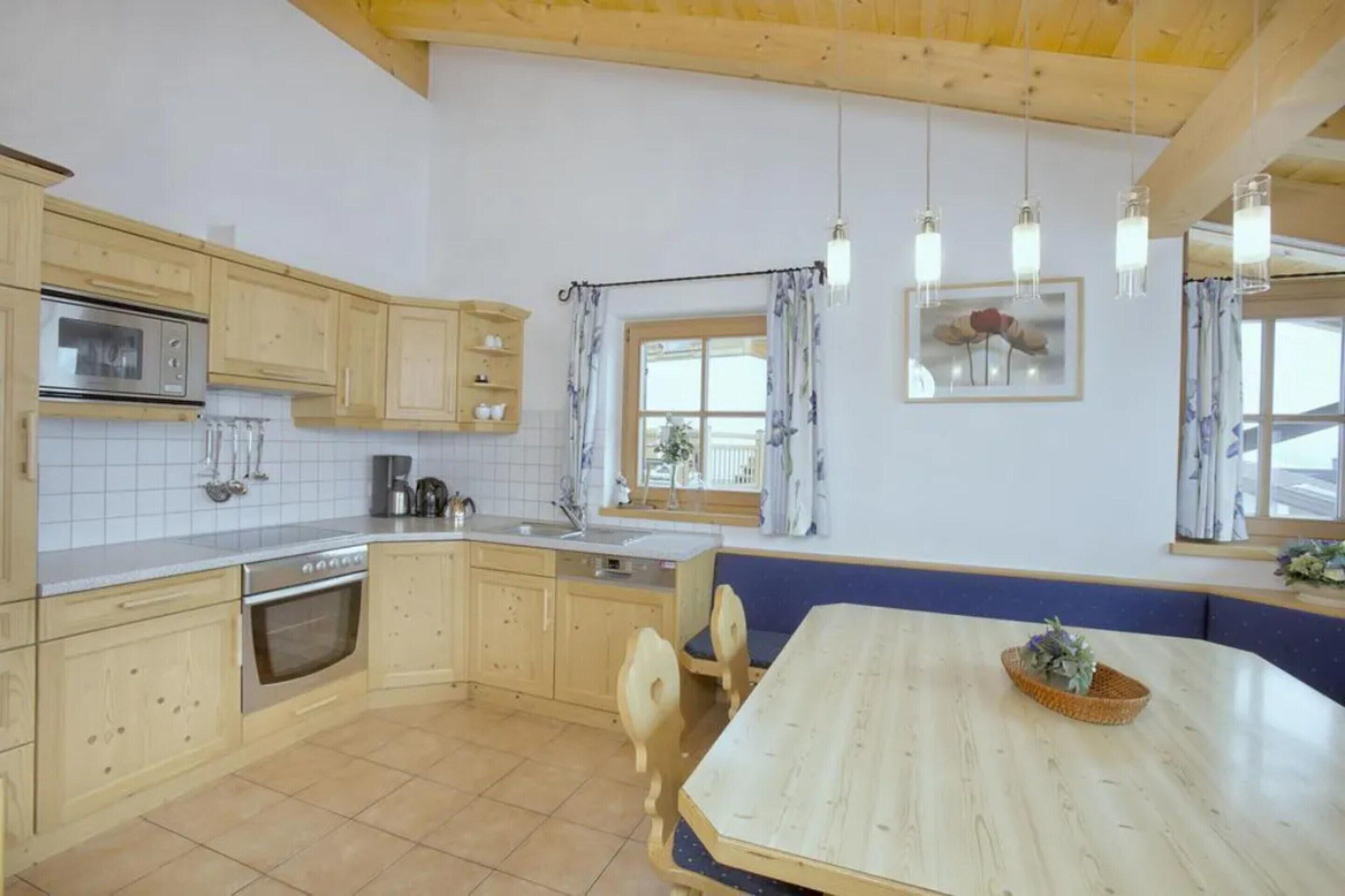 A kitchen with wooden cabinets, a built-in oven, a sink, and a dining table with chairs.