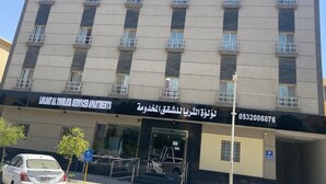 Un edificio de varios pisos con un letrero que indica que es un complejo de apartamentos con servicios.
