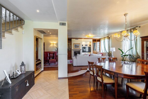 A spacious living area with a fireplace, a dining table, and a comfortable seating arrangement. - "Villa il Castellaccio," strategically located just 10 minutes from the beach (Rimini)
