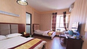 Hotellihuone, jossa on kaksi sänkyä, työpöytä, tuoli, lamppu ja ikkuna, jossa on verhot.