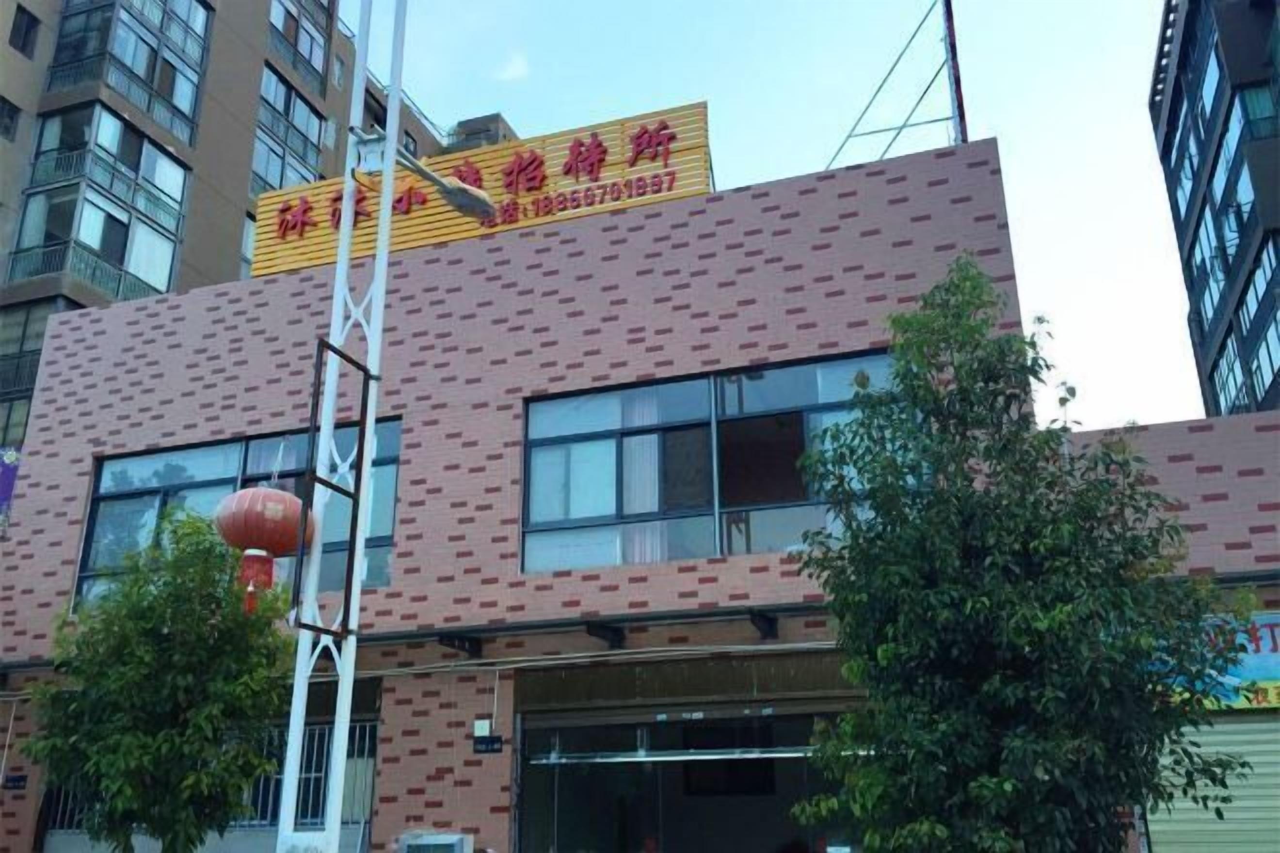 Un edificio con fachada de ladrillo, ventanas grandes y un letrero con caracteres chinos.