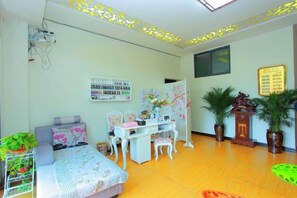 A room with a bed, desk, chairs, potted plants, and a bulletin board. - Kunming Mumu Xiaozhan (Chenggong University Town) (Kunming)