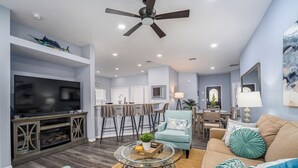 A modern living room with a TV, seating, and a dining area. - The Summerlight Villa - Games Room, Private Pool & Spa (Clermont)