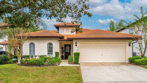 A two-story house with a tiled roof, a garage, and a well-maintained lawn. - The Summerlight Villa - Games Room, Private Pool & Spa (Clermont)