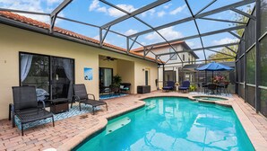 A covered swimming pool with lounge chairs and a patio area. - The Summerlight Villa - Games Room, Private Pool & Spa (Clermont)