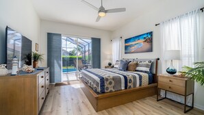 Een moderne slaapkamer met een groot bed, een bureau, een stoel en uitzicht op de omgeving.