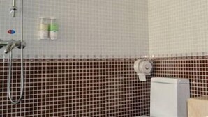 A bathroom with a shower, a towel rack, and a toilet. - Lavande Hotel (Shenzhen)