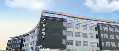A multi-story hotel with a prominent digital signboard displaying hotel information.