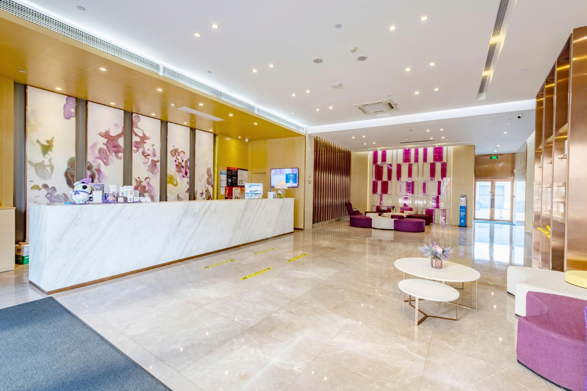 A hotel lobby with a reception desk, seating area, and a large window.