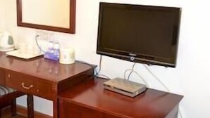A wooden desk with a flat-screen TV, a mirror, and a cabinet. - Lavande Hotel (Shenzhen)