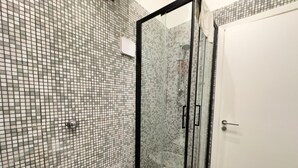 A bathroom with a glass-enclosed shower, a white sink, and a toilet. - Ale & Tizy House 2 Studio (Napoli)