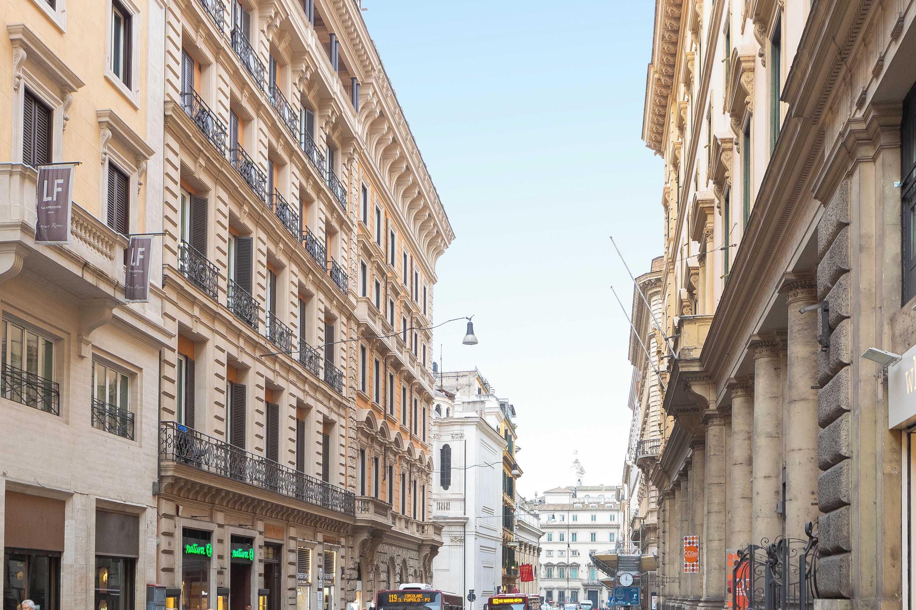 Eine Straße mit historischen Gebäuden, einem Glockenturm und einem Bus.