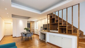 A spacious living area with a wooden staircase, a dining area with a table and chairs, and a fireplace. - Amazing Via del Tritone (Roma)