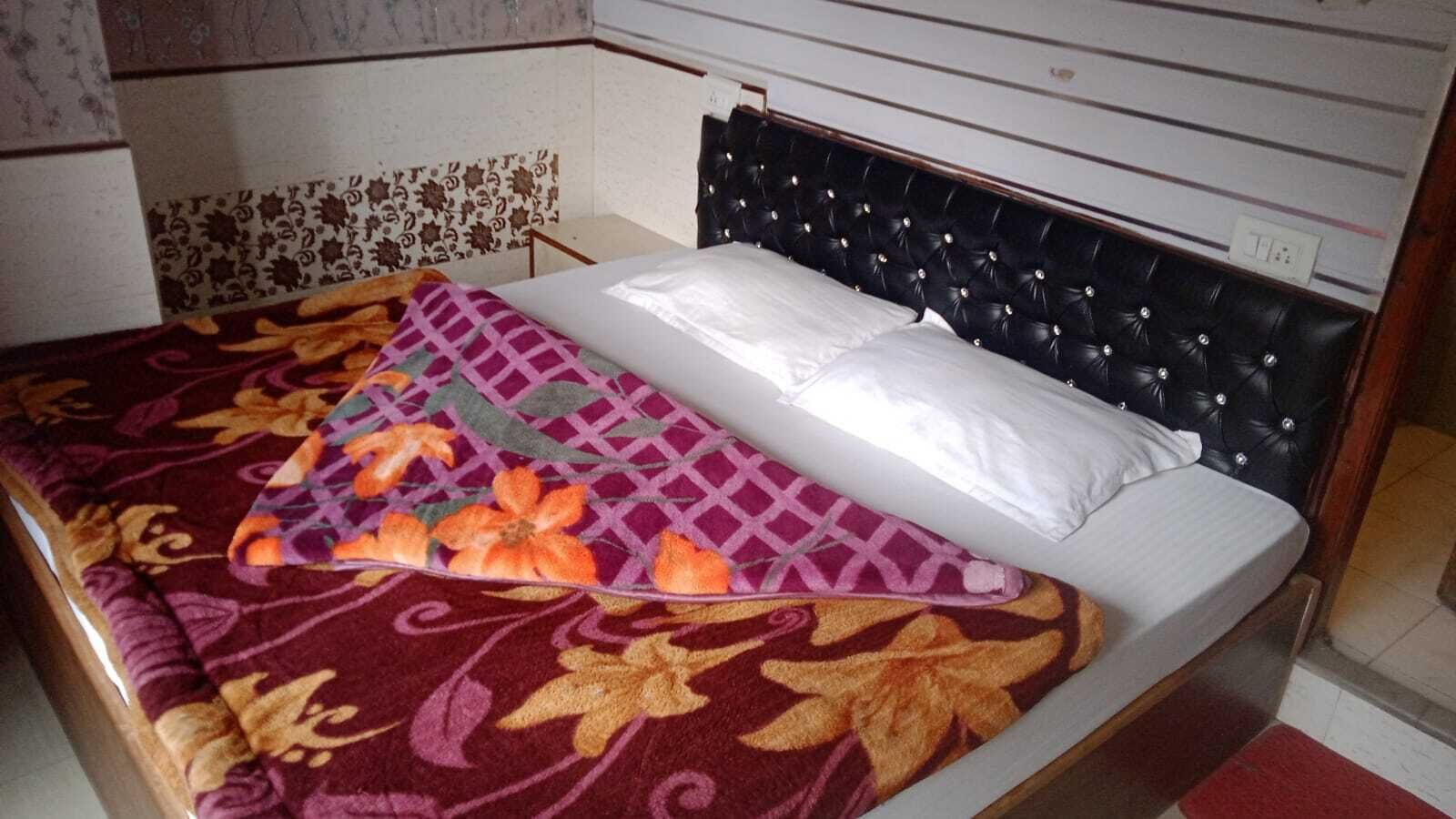Un lit avec une couvre-lit à motifs et une tête de lit capitonnée.