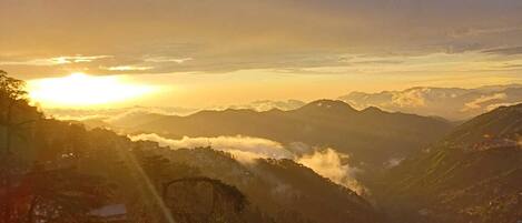 A mountainous landscape with a sunrise or sunset.