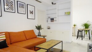 A modern living room with a sofa, coffee table, and a kitchen area in the background. - Arjona, modern and with excellent location (Sevilla)