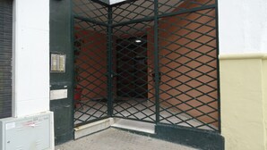 A corner entrance with a metal gate, a utility box, and a potted plant. - Arjona, modern and with excellent location (Sevilla)