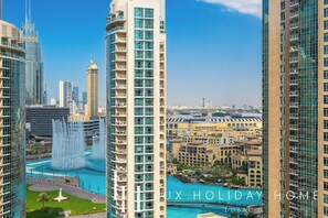 A high-rise building with a view of a water fountain and a pool. - LUX Burj Khalifa Fountain View Suite 2 (Dubai)