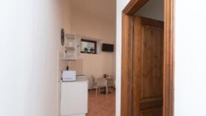 A hallway with a white refrigerator, a wooden door, and a tiled floor. - Jade 103 - Front of SMN Station - 2BR (Firenze)