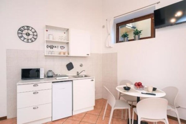 A compact kitchen with a microwave, kettle, and a coffee-themed shelf. - Jade 103 - Front of SMN Station - 2BR (Firenze)