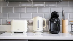 A kitchen counter with a Breville toaster, a Breville kettle, and a Tassimo coffee maker. - 1 Bed Northern Quarter Loft | City Centre | Air Conditioned (Manchester)