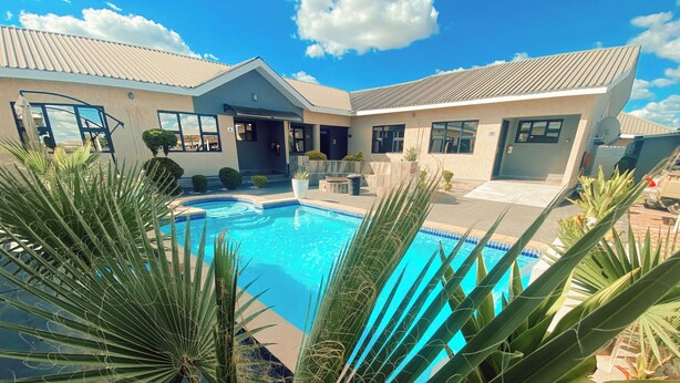 A swimming pool with a house in the background.