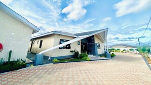 A modern building with a sloped roof, a covered entrance, and a paved driveway.