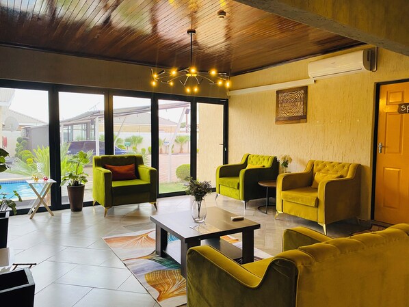 Un interior moderno con sofás amarillos, una mesa de centro y vistas al exterior.