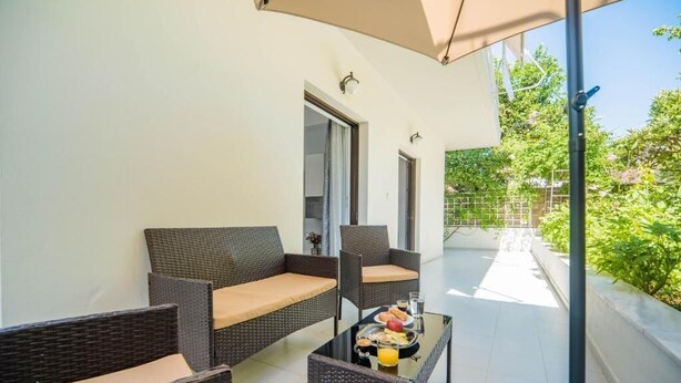 A balcony with wicker furniture and a table set with breakfast. - THE NEST OF URBAN LIVING by 8essentially (Chania)