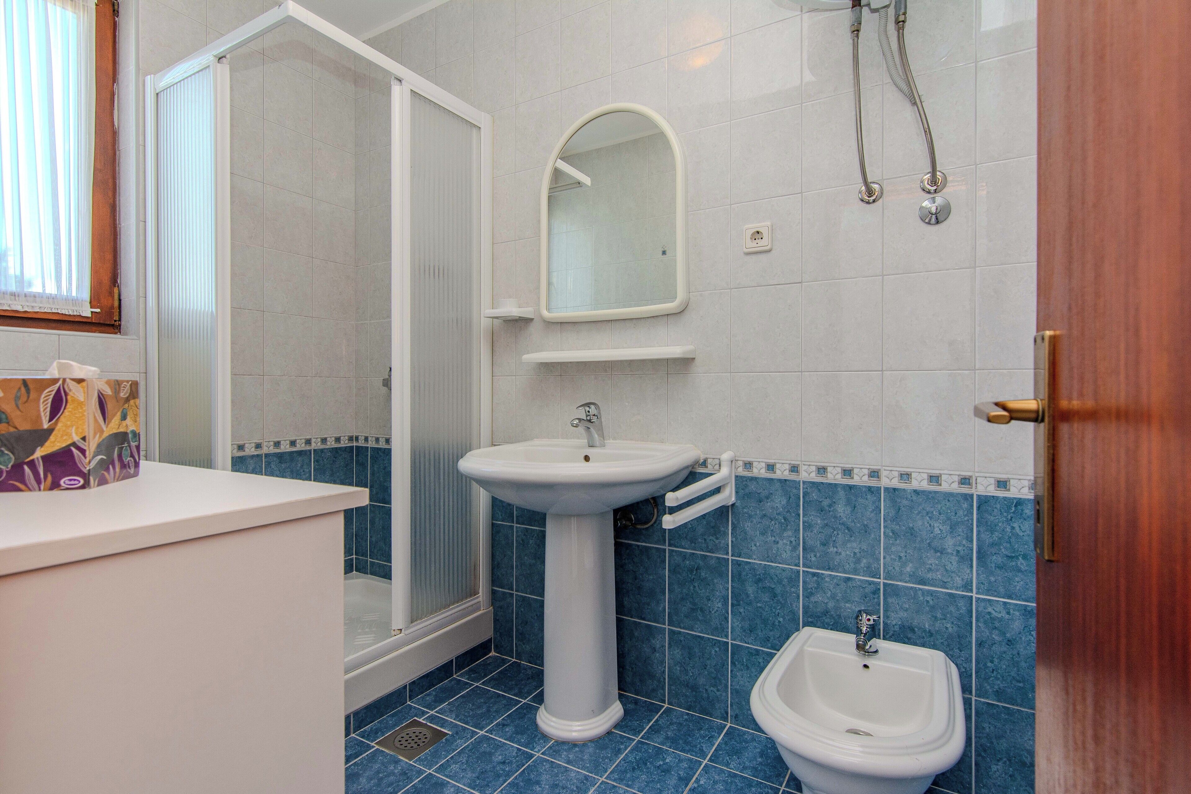 Une salle de bain avec une douche, un lavabo et un bidet.
