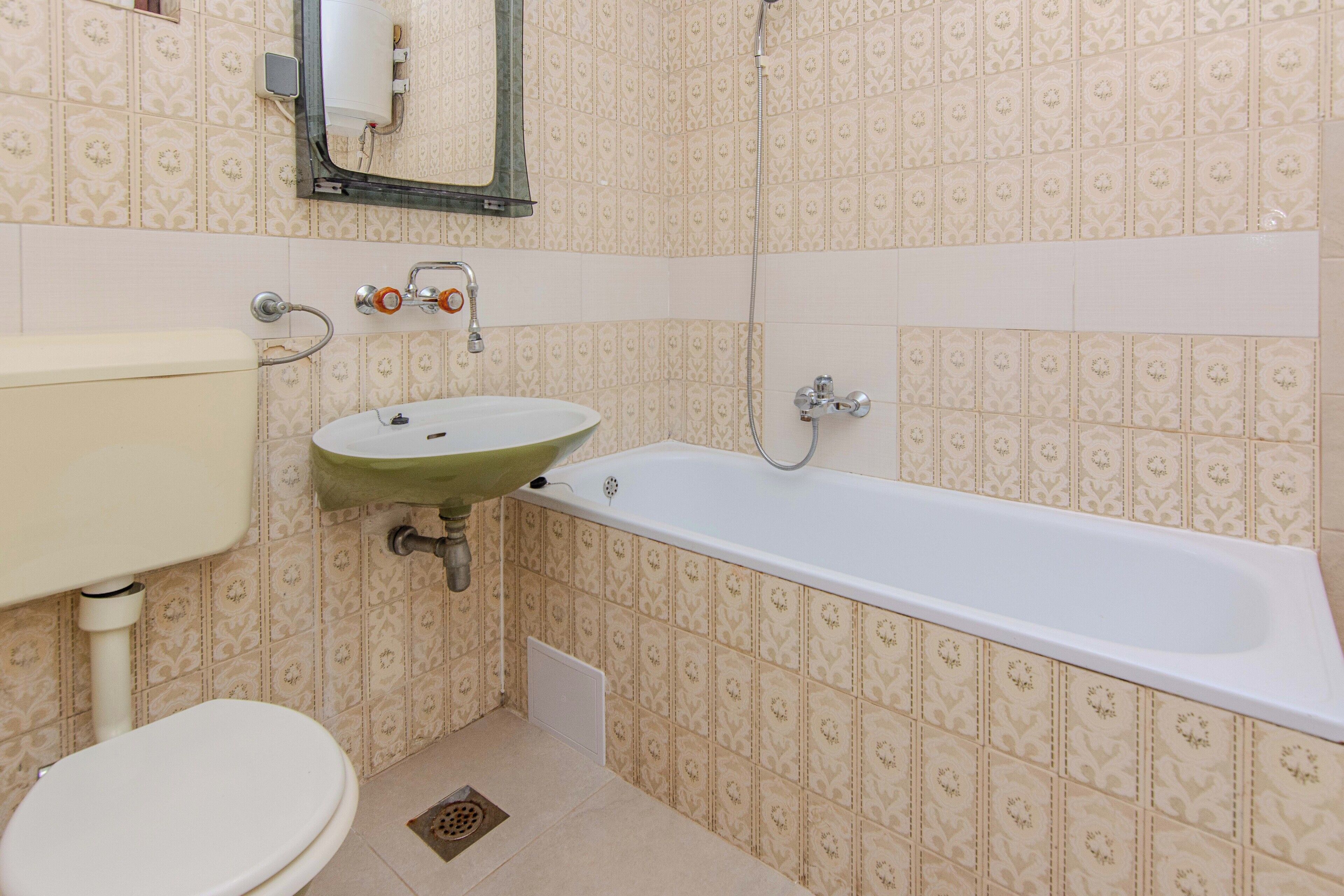 A bathroom with a toilet, sink, and bathtub.