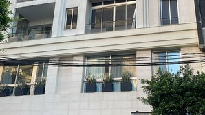 Un edificio a più piani con balconi, un ingresso carrabile e un ristorante in vista chiamato "ZITA".