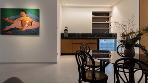Una cucina moderna con un piano di lavoro in marmo, mobili in legno e un'area pranzo con tavolo e sedie.