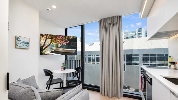 A modern apartment with a balcony, a dining area, and a kitchen. - Hyde Lane 1BR | Walk to Cafes + Pool + Gym (Wellington)