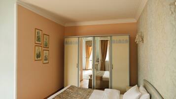 A bedroom with a bed, a wardrobe, and a mirror.