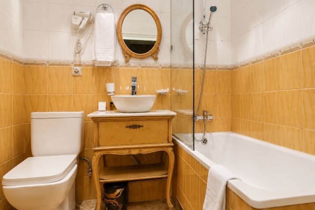 Une salle de bain avec des toilettes, un lavabo et une baignoire.