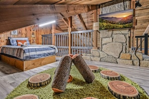 A cozy bedroom with a wooden bed, a stone wall, and a large window.
