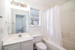 Ein Badezimmer mit einem weißen Waschbecken, einer Toilette und einer Badewanne.